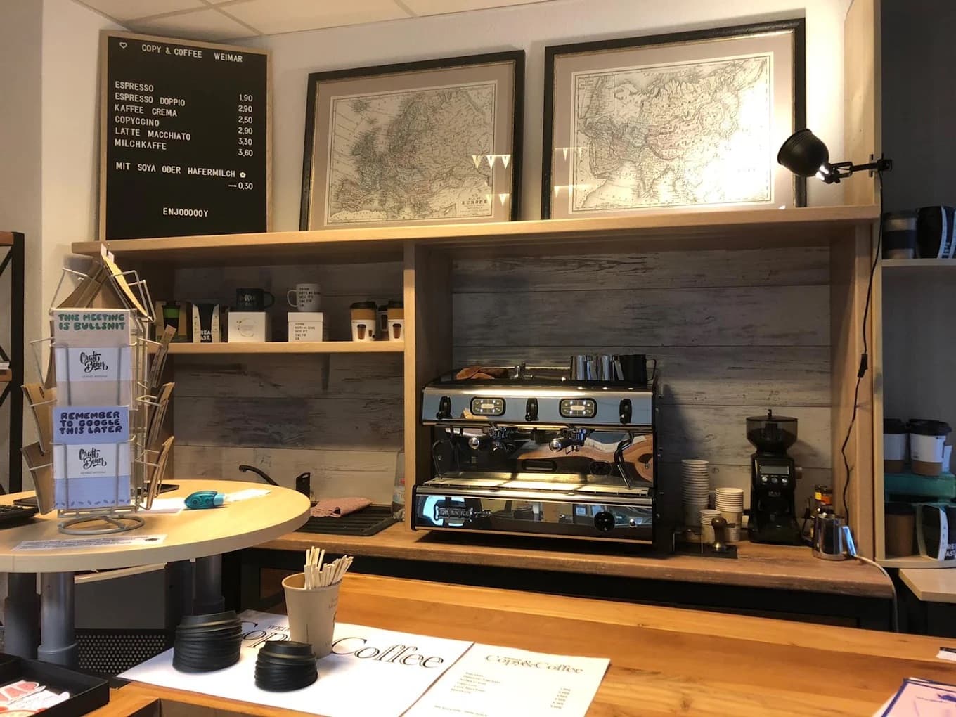 Unsere Theke mit Siebträger-Espressomaschine, Mühle und der Kaffeekarte an der Tafel