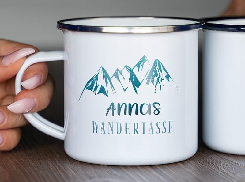Emailletasse mit Bergmotiv und Aufschrift „Annas Wandertasse“